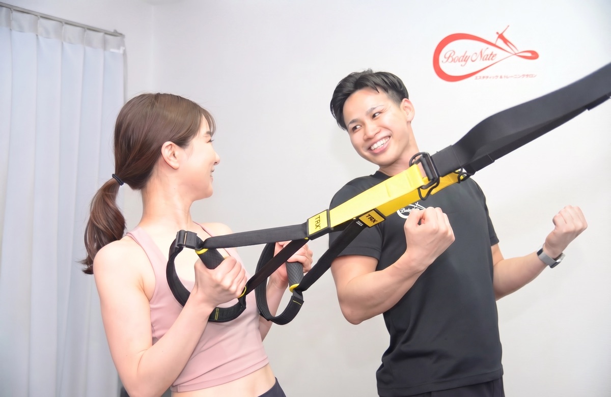 Body Nateでトレーニングする女性とサポートする男性トレーナー